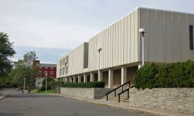 The south facade, with the library and auditorium, feature a stone retaining wall, brick ground storey and pre-cast concrete upper floors