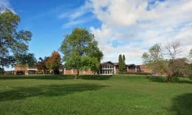 The two-storey classroom wing enfolds the 16-sided pavilion. The subsequent addition of a gym is seen at the right