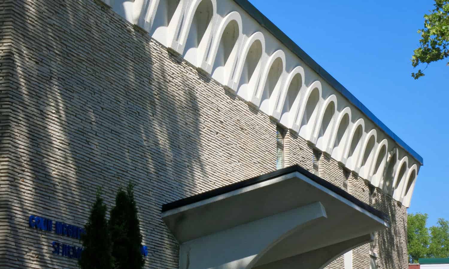The character-defining stone cladding, concrete entablature, and expressive portico are associated with New Formalism