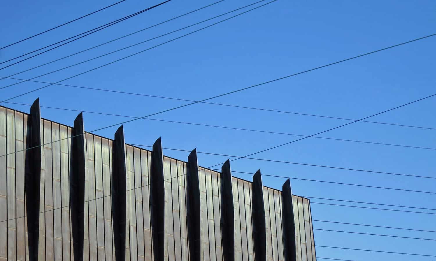 Amidst the hydro lines, the volume of the sanctuary is characterized by the rhythm of columns and the copper cladding