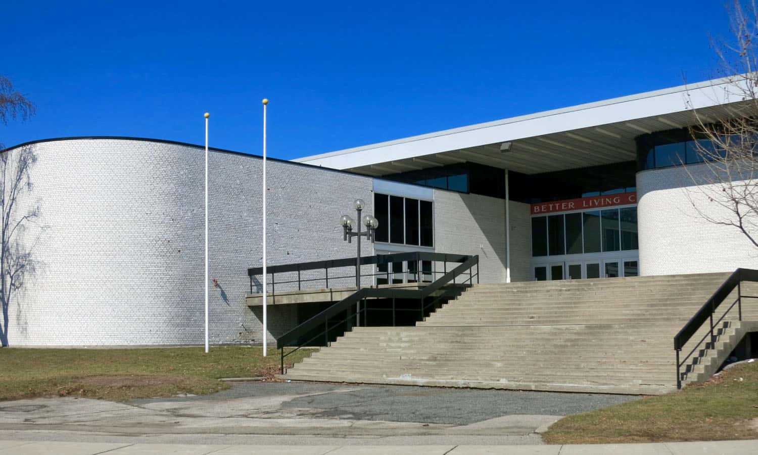 Entrances are characterized by recessed doors, broad concrete terraces and steps